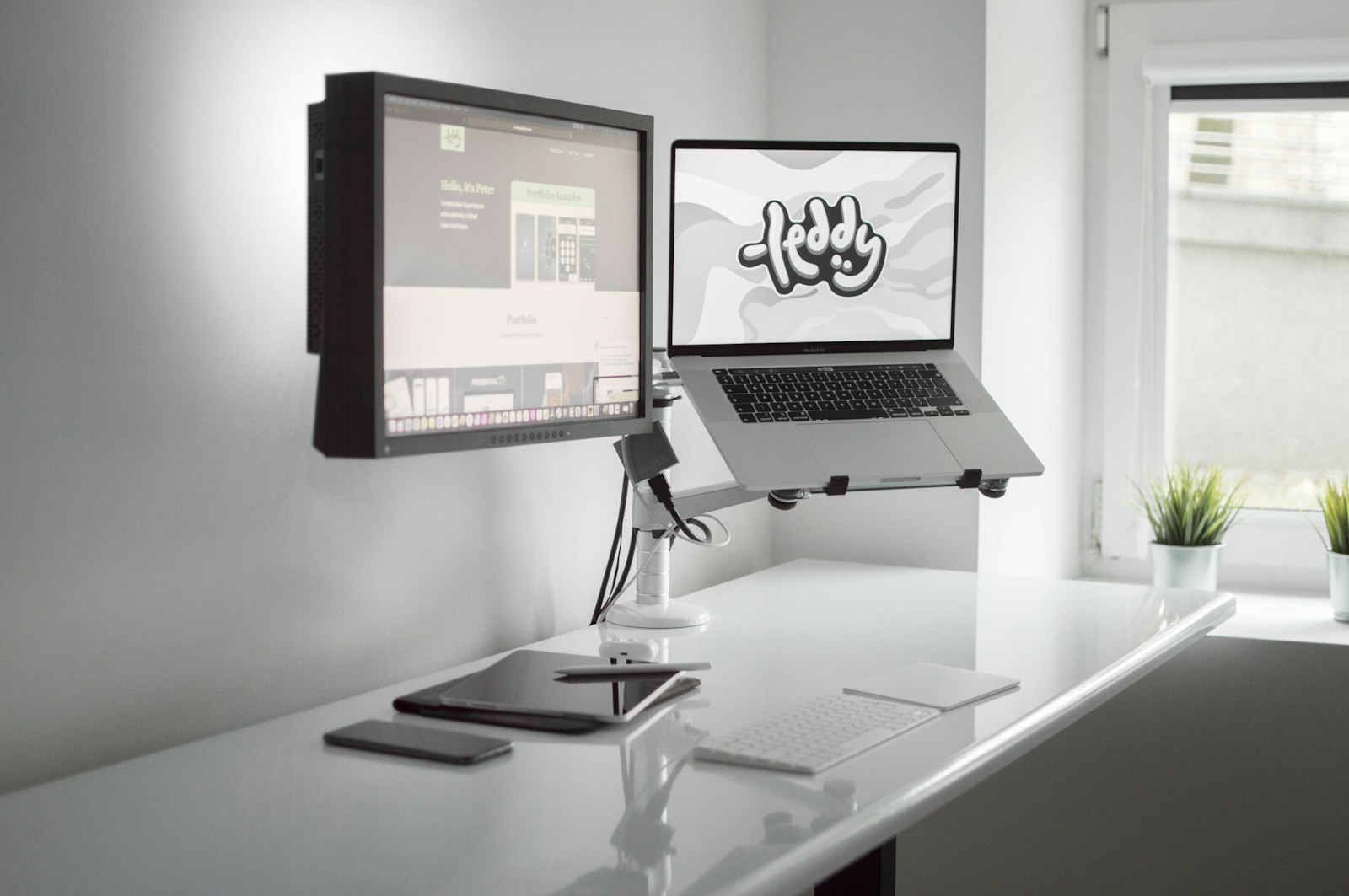 A monitor mounted on a white adjustable arm over a compact desk.
