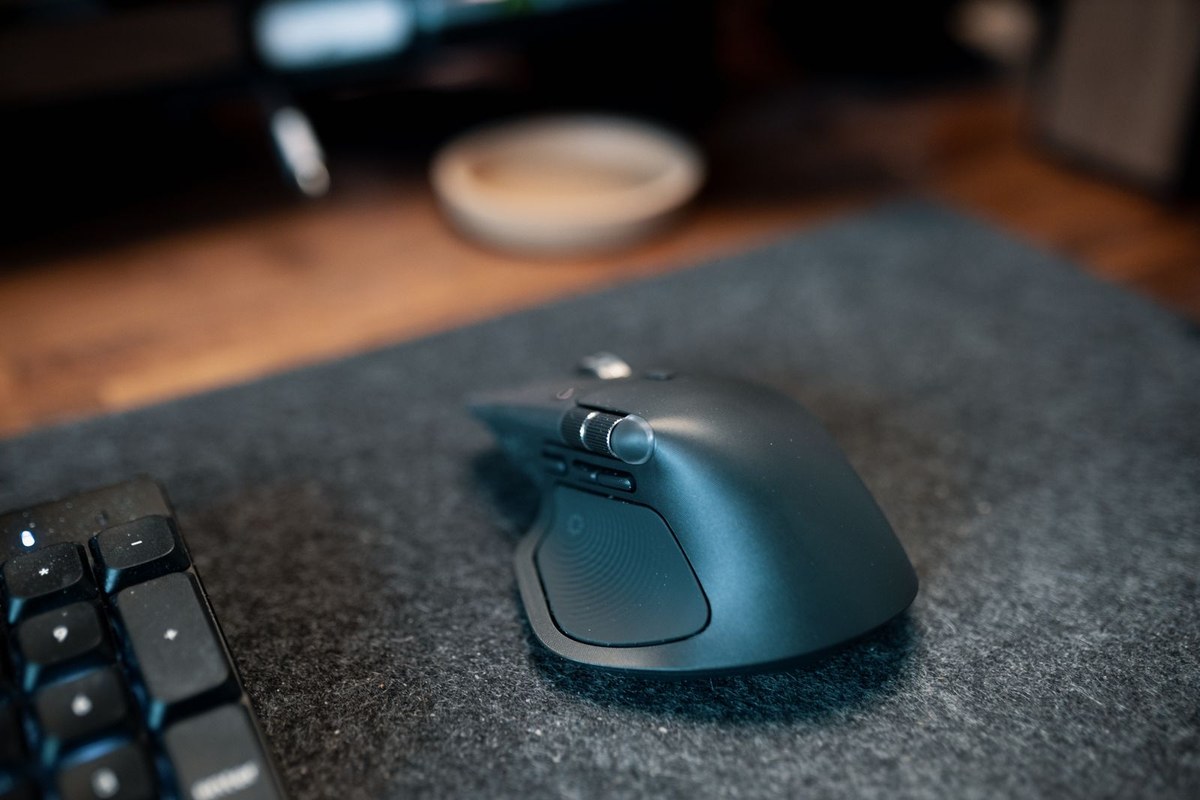 Close-up of a wireless mouse resting on a textured felt desk mat.