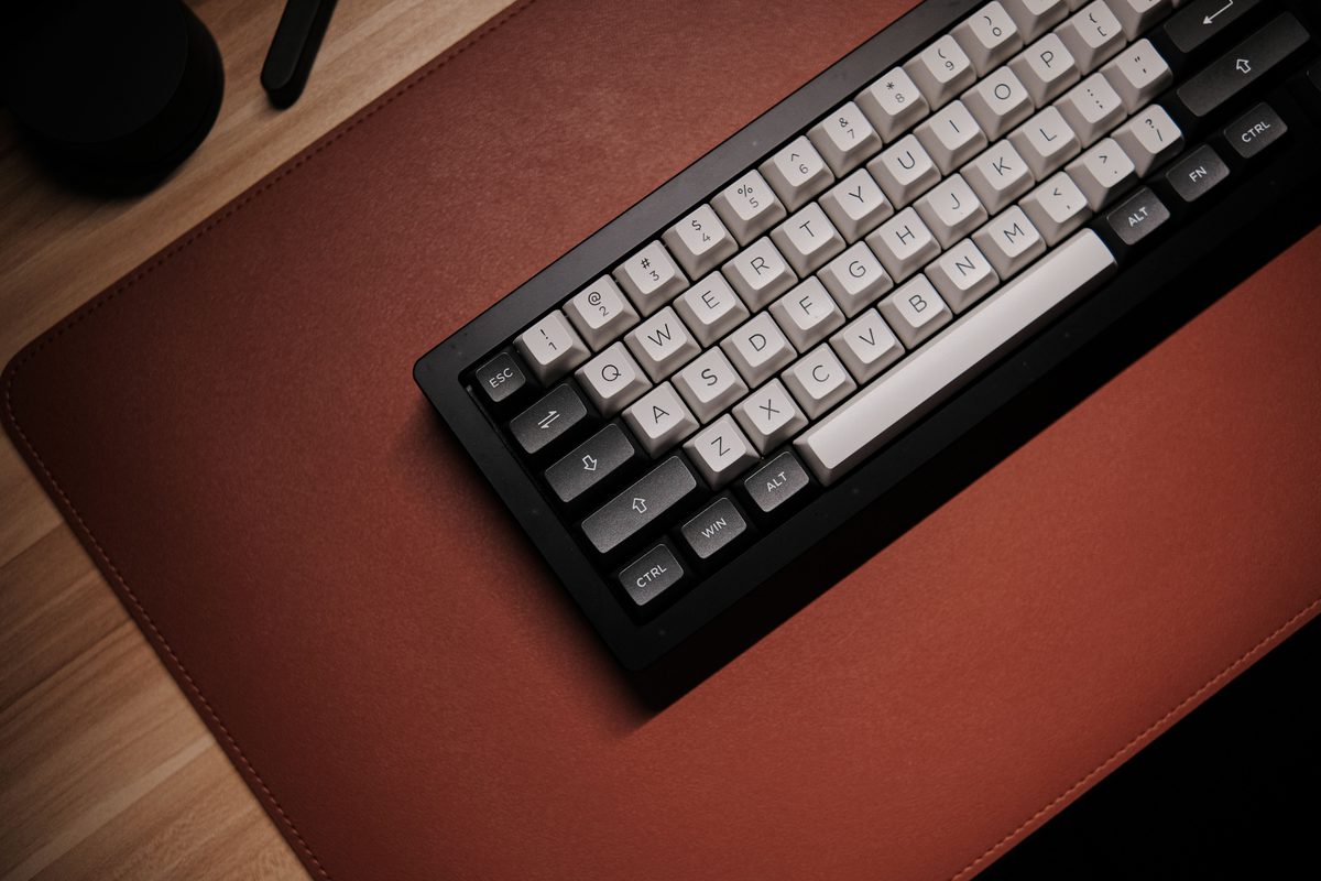 Representative photo: a mechanical keyboard resting on a stitched brown leather desk mat. Not the YSAGi product.
